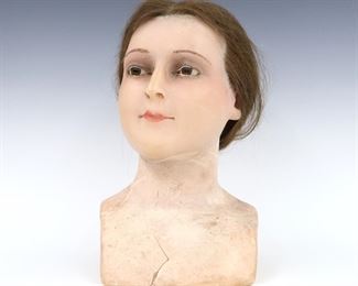 An early 20th century wax mannequin bust. Realistic wax head of a young girl with real Light Brown hair, inset glass eyes, hand-painted lips, and traces of hair eyebrows and eyelashes. Wear and losses, crack to wax at chest. 13" high. ESTIMATE $300-400