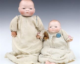 Two 1920's Grace Storey Putnam "Bye-Lo Baby" dolls. Bisque socket heads with sleep eyes on jointed cloth bodies with composite hands. Smaller wearing original muslin gown with "Bye-Lo Baby" tag and button. Each impressed "Grace S. Putnam" at back of necks, larger copyrighted "1923". Some wear to surface to paint, smaller with repair to back of head and stained fabric, larger with cracks to composite hands. Up to 14" long. ESTIMATE $100-150