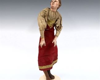 An 18th to 19th century Neapolitan creche or presepio figure. Standing female figure with Earthenware head and inset glass eyes on a hemp wrapped wire body with wooden lower limbs and polychrome painted detail. Some wear and damage, losses to one hand and arm, fabric with tears and some stains. 15" high. ESTIMATE $100-200