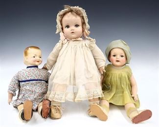 Three early 20th century American composite dolls. Includes an Ideal Toy Co. "Snoozie Smiles" with two-face composite head on a jointed cloth body with composite lower arms wearing a floral onesie, a Madame Hendren girl with full composite head, sleep eyes and mohair wig on a jointed composite body wearing a Green dress, and a Madame Alexander baby doll with composite head, sleep eyes and mohair wig on a jointed cloth body with composite lower limbs wearing a White gown. Some wear to paint and surface, craquelure and flaking to composite, fabric with some wear and fading. Up to 19" high. ESTIMATE $100-200