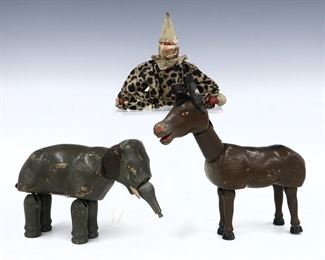 Three early 19th century Schoenhut "Humpty Dumpty" circus figures. Jointed wooden figures with painted detail, includes an elephant, a donkey and circus clown. Wear and minor damage, inner stringing loose, lacking some small elements. Up to 8" long. ESTIMATE $50-100