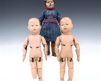 Three early 20th century Schoenhut dolls. Wooden socket heads with painted detail on jointed wooden bodies, one wearing a Blue dress and the others without clothing. Two with original "Schoenhut" stickers and one with impressed mark. Wear and some damage, flaking to paint, one lacks a foot. Up to 14" long. ESTIMATE $100-200