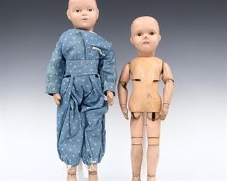 Two early 20th century Schoenhut dolls. Wooden socket heads with painted detail on jointed wooden bodies, one wearing a Blue onesie and the other without clothing. One with original "Schoenhut" sticker and one with impressed mark. Wear and some damage, flaking to paint, one with touch-ups to face. Up to 18" long. ESTIMATE $100-200