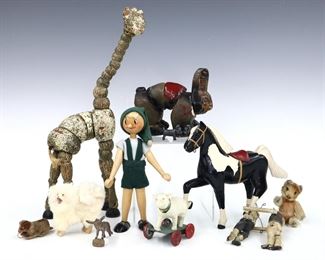 Twelve early to mid 20th century children's toys. Includes a Twistums giraffe and bunny, a wooden horse, wooden Pinocchio, a pair of wooden acrobats, a Steiff type bear, two Ideal Dog Food advertising "Good Luck" charms, and others. Wear and minor damage overall. Up to 14" high. ESTIMATE $50-100