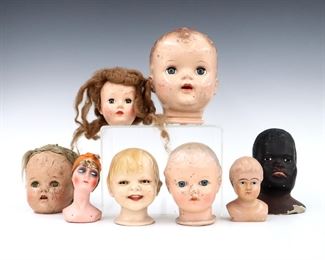 Eight antique and vintage doll heads. Composition, biscaloid, paper mache and celluloid heads by makers including Ideal Toy Co., "Gladdie" by Helen W. Jensen, and Effanbee. Wear and damage overall, as-is.