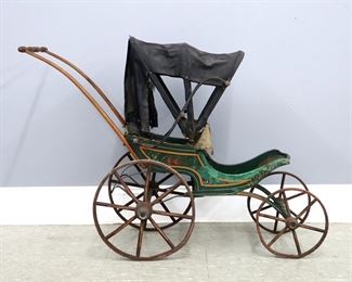 A 19th century Victorian Period child's doll carriage. Shaped wooden carriage with Green painted finish, upholstered seat and folding parasol on an Iron frame with wooden spoked wheels. Wear and some damage, losses to folding cover. Approx. 40 x 14 x 26" high overall. ESTIMATE $100-200