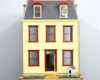 An early 20th century doll house, c. 1910.  Wooden Georgian style house with three stories and mansard roof, features a Green painted exterior with Burgundy trim and shutters, glass windows and Green slag glass transom window over front french doors, on an incorporated wooden base.  Back reveals interior with six rooms and papered walls, includes approx. twenty pieces of wooden doll furniture.  Re-painted, lacks one french door, some wear and shrinkage.  House is 26 3/4 x 24 1/4 x 37 1/2" high, base is 27 1/4 x 34 x 2 1/2" high overall.  ESTIMATE $300-400
