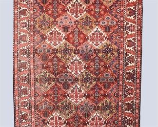 A 5.4 x 10' vintage Caucasian carpet. Multicolor floral design on a Red/Pink field. Some wear and fading, minor staining to fringe. ESTIMATE $400-600