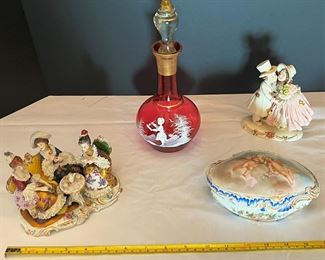 #17. $70. Lot of (4): German Porcelain Figure and Box, French Porcelain Children Figure & Gilt Ruby Decanter (chipped at rim).