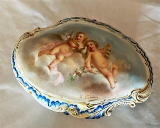 #17. $70. Lot of (4): German Porcelain Figure and Box, French Porcelain Children Figure & Gilt Ruby Decanter (chipped at rim).