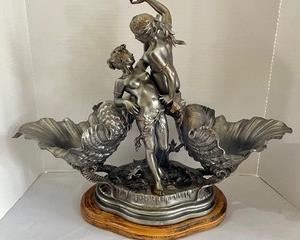 French Spelter Centerpiece Sculpture Charles Georges Fertile Suan. Item features cast shelter metal sculpture, double maiden figurines, shell double dishes and a serpent at the base. Signed on the base, Ferville Suan. 

By sculpture, Charles Georges Ferville Suan (French, 1847-1925)

Measurements; 17.5" h x 23" w x 8" d. There is one loose screw on the bottom which can be seen in the photo gallery. 
