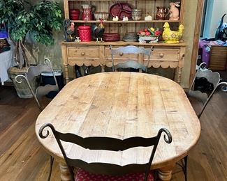 Oval pine dining table with four wrought iron chairs, two matching wrought iron barstools, not show