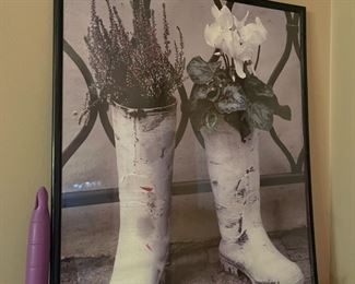 Hanging picture of rain boots growing flowers in frame