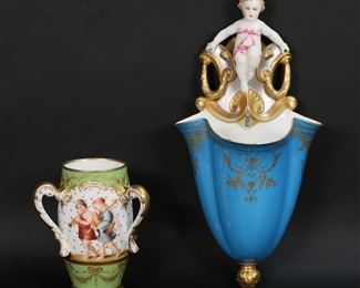 28	Dresden Klemm Vase & Cherub Wall Pocket	2 piece porcelain lot. Richard Klemm Dresden German porcelain three handled vase, hand painted with children, gilt enamel decoration, gilt painted handles and rim, blue RK under crown Dresden Germany and partially obscured Limoges marks to the underside, 6 3/8"H. With a figural cherub porcelain wall pocket, 14 1/2"L. Klemm vase minor losses to gilt decoration on rim and handles; wall pocket losses to git decoration throughout, scratches and discoloration to rim at front, discoloration to interior.
