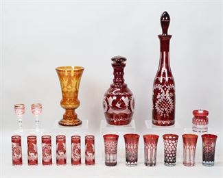 40	18 Pieces Bohemian, Ruby & Cranberry Glass	18 piece glass lot, including ruby, cranberry and Bohemian glass. 7 piece ruby Bohemian glass set, with decanter and six cordials, decanter 9 3/4"H; ruby Bohemian decanter with grape motif, 16"H; 6 ruby color to clear glasses including one pair, each 4"H; pair of cranberry to clear cordials with gilt rims, each 4"H; cranberry cut to clear mustard / condiment jar, 3 1/4"H; amber Bohemian glass vase, 8 1/4"H.
