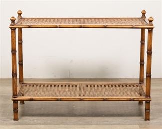53	Regency Style Faux Bamboo Tiered Caned Table	"Regency style faux bamboo caned side table. 20th century. Two caned tiers, bamboo form legs, knob-form finials. Scratches and scuffs to wood on top edge near one corner. Split to wood on one leg of table. Nicks and marks to edges of wood on lower tier of table.

36"" W x 14 1/2"" D x 27 3/8"" H. 12 lbs."

