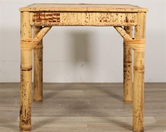 56	Hollywood Regency Style Bamboo Card Table	"Hollywood Regency style bamboo card table. 20th century. Woven top, inlaid bamboo apron, large bamboo legs. Wear, marks, and small tears to woven top of table. Splitting and cracks to bamboo on two legs. Separations and tears to weaving on one leg. Weaving on one leg is slightly loose. Chip and loss to bamboo on foot of one leg. 

29 1/2"" W x 29 1/2"" D x 29 1/2"" H. 24 lbs."
