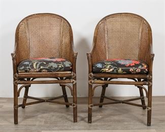 57	Pair of McGuire Faux Bamboo and Cane Chairs	"Pair of Hollywood Regency style faux bamboo and cane chairs by McGuire. San Francisco, 20th century. Double caned back, faux bamboo frame and stretcher. Metal McGuire tag on underside of seats. Tears and losses to leather on arms of one chair. Scuffs and scratches to faux bamboo throughout arms of chairs. Original caned seating on one chair is replaced with plywood board. Scratches and marks to legs of both chairs. Wear to seat cushions. Tears to caning on seat of one chair.

21 5/8"" W x 22"" D x 36 1/2"" H. Seat height 20 1/2"" H, arm height of 24"" H. 13 lbs."

