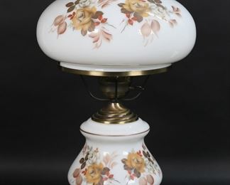 91	Milk Glass Gone With the Wind Lamp	Electrified Gone With the Wind table lamp. Milk glass with transfer floral decoration and brass and gilt metal fittings. 25"H, shade 9 3/4"-diameter at bottom. Chips and roughness along bottom rim of shade, losses to brass patina on fittings and base.
