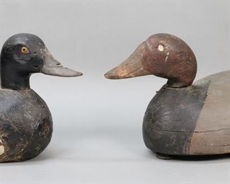 100	2 Wood Carved Duck Decoys	2 carved wood duck decoys. Both unsigned. 19"L and 14"L. Paint loss and chips to both; smaller split to underside, chips to beak, chips to tail feathers; larger chips and splits to body, large chips to neck.
