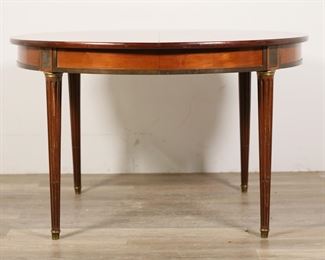 111	French Directoire Style Dining Table	"French Directoire style  dining table. Early 20th century. Circular form, reeded colonnade legs, brass mounts and foot caps. Two central legs unfold and  drop down when table is open and extended. Three additional leaves are included. Scratches, marks, and gouges to wood on top of table. Scuffs, nicks, and wear to wood of legs. Tarnishing and wear to brass mounts and foot caps. Scuffs and marks to wood throughout apron of table. Tape residue and marks to underside of table. Marks, scuffs, and scratches to wood on edges of table leaves. Scratches to tops of leaves. 

 29 1/8"" H x 47 1/8"" diameter. Each leaf measures 47 1/8"" W x 19 1/2"" D. Extended with three leaves: 106"" W x 47 1/8"". 133 lbs."
