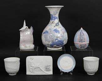 151	7 Pieces Lladro Porcelain	"7 piece Lladro porcelain lot. Lladro Society dove plaque, 6 3/4""H; Lladro Collector's Society Don Quixote plaque, 5 3/4""L; 2 Lladro Collector's Society cups, 1997 Sailing the Seas and 1998 Dolphins at Play, each 3 1/2""H; duck plate, 4""-diameter; Spring Egg, 5""H; Sparrows flower vase, 10""H.

Discoloration to the interior of both cups, Spring Egg white flower petals chipped and one flower detached (piece present)."
