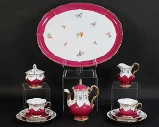 174	10 Piece Meissen Porcelain Dessert Set	10 piece Meissen German porcelain dessert / coffee set. Magenta with floral decoration. Platter, coffee pot, lidded sugar bowl, creamer, 2 cups, 2 saucers, 2 dessert plates. All with blue crossed swords marks. Platter 17"L, coffee pot 7 5/8"H. Chip to the base of one cup, repair to the rim of sugar bowl, finial on lid of coffee pot chipped and repaired.
