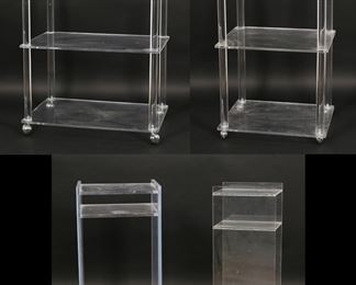 184	Four Mid Century Modern Acrylic or Lucite Stands	"Four Mid Century Modern acrylic or Lucite rolling stands. 20th century. Three stands on casters and one desk organizer. Two produced by Plastic Works, with ""PlasticWorks!"" labels on lowest tier on each stand.  Light scuffs, scratches and wear throughout acrylic of all pieces. Remnants of paper affixed to top tier of one Plastic Works stand. Brown stains to top tier on edge on smallest stand. 

Tallest stand: 18"" W x 14"" x 31 1/8"" H. Widest stand: 24 1/8"" W x 16 1/8"" D x 26 1/4"" H. 66 lbs total."
