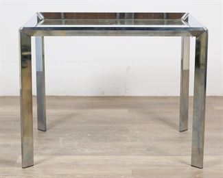 194	Milo Baughman Style Mid Century Side Table	"Mid Century Modern side table in the style of Milo Baughman (Goodland, KS, 1923-2003). Circa 1973. Chrome table with inset mirrored top. Remnants of ""NOV 15 1973"" stamped onto underside of mirrored top. Small label with ""DIA"" on underside of one top holder. Scratches and scuffs to mirrored top. Desilvering to edges of mirror. Scuffs and wear throughout chrome of table base. 

28"" W x 22"" D x 21 3/4"" H. 23 lbs."
