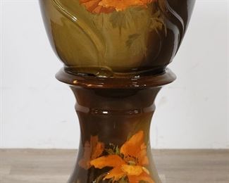227	Weller Louwelsa Pottery Jardiniere & Pedestal	Weller Louwelsa pottery jardiniere and pedestal. Unsigned. Brown and green glaze with floral decoration. 28"H, jardiniere 14 3/4"-diameter at top. Crazing to both, scratches to pedestal top, chips to underside of pedestal, chip to base of pedestal, scratches to jardiniere, chips to base and underside of jardiniere, discoloration to interior of jardiniere.
