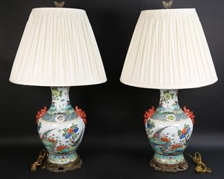 236	Pair of Chinese Porcelain Vases Tongzhi Marks	Pair of Chinese porcelain vases, drilled and mounted as lamps. Hand painted with bird, flower and cherry blossom motifs, foo dog handles. Red six character Tongzhi marks to the undersides. As lamps each 32 3/4"H including harps and butterfly finials, vases 16 1/2"H. Both drilled, tear to inside of one fabric shade, paint loss to one foo dog.

