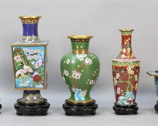 238	5 Piece Chinese Cloisonne Lot	5 pieces Chinese cloisonne. Bowl and 4 vases, each on wooden stand. Square vase with crane decoration, 10 1/4"H not including stand; green vase with cherry blossom decoration, 8"H not including stand; red vase with bird and cherry blossom decoration, 9"H not including stand; hexagonal vase with bird and flower decoration, 10 1/4"H not including stand; bowl with flower decoration, 3 3/4"H x 6 7/8"-diameter at top not including stand. Minor losses and scratches to gilt on all.
