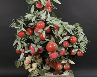 243	Large Chinese Hardstone Fruit Tree	Large Chinese jade and hardstone apple tree. In a hardstone planter. 24 1/2"W x 29"H. Large chip to one leaf, minor chips to leaves throughout and planter.
