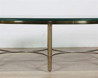 246	Mastercraft Hollywood Regency Cocktail Table	"Hollywood Regency style cocktail table produced by Mastercraft. 20th century. Beveled oval glass top, bamboo form legs, curving stretcher. No apparent maker's marks or labels. Tarnishing, staining, and wear throughout brass of table base. Scratches and scuffs to glass on top and along edges. Large chip to glass on one end of table.

52"" W x 27"" D x 17 1/4"" H. 100 lbs."
