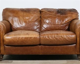 260	Natuzzi Style Italian Leather Loveseat Couch	"Leather love seat in the style of Natuzzi. Italian, 21st century. Seat and back cushions are fixed in place. Manufacturer labels and ""MADE IN ITALY"" on tag on underside of love seat. As is, with wrinkling, scratches, wear and staining throughout leather of loveseat. White scuffs to leather on left, right and lower front sides of loveseat. Heavy scratches to leather on arm. Nicks, scuffs and chips to wood on feet of loveseat. Long scratches, scuffs, and marks to leather on back of loveseat. Tears and losses to leather on right back cushion. Depression to right back cushion. 

66"" W x 38 1/2"" D x 34 1/2"" H. 102 lbs. 

"
