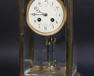 296	Le Roy French Mantel Clock AD Mougin	French mantel clock. Brass and glass case, enamel face. Face marked Le Roy, Paris France; works AD Mougin Made in France. 6 7/8"W x 5 3/8"D x 11 5/8"H. Lines and chips to face, oxidation and losses to patina on brass throughout case, oxidation and losses to patina on pendulum, chip to glass on one side. Clock not running.
