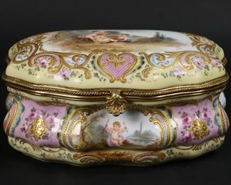 317	Sevres Style Porcelain Box Signed Max	Sevres style porcelain dresser box or jewel casket. Gilt bronze mounts, gilt enamel and hand painted decoration. Hand painted scene with cherubs and a bird on the lid, signed Max. Scene of Cupid on the front and a landscape on the reverse. Blue crown mark to the underside. 8"L x 4 3/4"D x 3 3/4"H. Scratch through Cupid scene on front, minor losses to gilt decoration on reverse, minor losses to patina on mounts.
