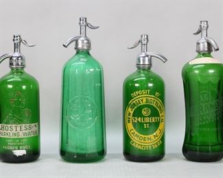 327	4 Vintage Green Glass Seltzer Bottles	4 green glass seltzer bottles / soda siphons. New Jersey Bottling Co., A.G. Grande's Beverages Brooklyn NY, Farber Bros. Hostess Sparkling Water, ribbed Czech bottle with CBQ Co. Tallest 12 1/2"H. All with some discoloration to the interiors and losses to metal tops, loss to painted labels on Hostess and New Jersey bottles, remnants of paper labels on Grande's and Hostess bottles.
