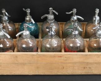 328	10 Vintage Glass Seltzer Bottles Chicago, St Louis	10 vintage glass seltzer bottles / soda siphons. St. Louis, MO: Silver Seal Seltzer American Soda Water Co., Clover Leaf Brand Enno Sander Seltzer & Soda Co.; Chicago, IL: Lincoln Bottling Co., Peacock Sparkling Water Peacock Ale Co., Canfield's Beverage, Consumers Beverage Co. textured bottle; Bloomington, IL: City Bottling Co.; Baltimore, MD: White Eagle; Milford, CT: Castle Seltzer Inc. blue glass bottle with paper label; Barnett Bros. good health bottle. Consumers bottle 11"H. In a wooden box. Chips to bottom of Silver Seal bottle, flake to front of Clover Leaf bottle, flakes to Lincoln bottle, flake to Peacock bottle, Barnett Bros. bottle losses to painted lettering, minor losses to lettering on City Bottling bottle, Consumers bottle siphon missing top. All with losses to metal tops. Chips, losses and wear to box.
