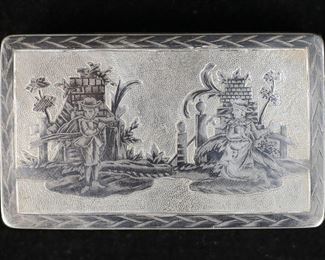 372	Russian 84 Silver Niello Work Tobacco Box	Hallmarked Russian 84 (875) silver tobacco / snuff box. Neillo work decoration with two figures on lid and two houses on underside of box. Gold wash interior. Interior of lid and box both stamped 84 with two other illegible marks. 3 1/8"L x 1 7/8"W x 5/8"H. 83.03 grams. Losses and discoloration to gold wash on interior, tarnishing to box.

