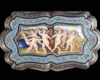 374	800 Silver & Enamel Pill Box	800 silver and enamel pill box or compact. Lid with enamel and hand painted scene with cherubs. Gold wash interior, interior of lid stamped 800 with standing lion. 3 1/4"L x 1 3/4"W x 1/2"H; 72.01 grams total.
