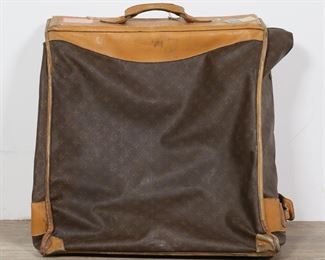 379	Vintage Louis Vuitton Folding Hanging Garment Bag	"Vintage Louis Vuitton folding garment bag for hanging clothes. Mid 20th century. Monogrammed canvas and leather with brass hardware. Label on inside states ""LOUIS VUITTON PARIS FRANCE MANUFACTURED BY THE FRENCH CO., USA UNDER SEPCIAL LICENSE."" Heavily used for travel. As is, with airline tags, scuffs, staining and wear throughout exterior and interior liner of bag. Tarnishing and oxidization to brass hardware. Tear to leather on one end of bag.

25"" W x 13"" D x 24"" H. 16 lbs."
