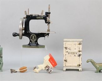 389	Lot of Miniatures	Cast iron Eagle stove with frying pan and Alaska ice box miniatures, both possibly Hubley, ice box 5"H; Singer miniature sewing machine with hand crank, 7"L x 7 1/8"H; miniature block & tackle; Langcraft miniature electric outboard motor, 3 3/4"H; American Museum of Natural History SRG Co. cast metal brontosaurus dinosaur figurine, 7"L. Minor paint loss to stove, paint loss throughout ice box, ice box one hinge on lower door cracked.

