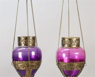 396	Pair of Amethyst Glass & Brass Hanging Fixtures	Pair of Indian purple glass and brass hanging light fixtures. Each 17"L to top of caps. Chips and roughness to top rim of lighter colored shade.
