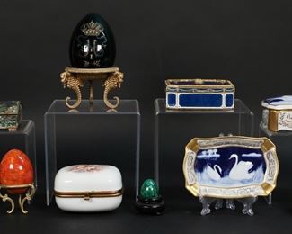 407	Lot of Trinket & Dresser Boxes, Eggs	Lot of boxes and eggs. Trinket, jewelry and dresser boxes including Italian gilt and enamel box, E monogram with jeweled decoration, 3 5/8"L x 3"W x 1 1/4"H; Alpaca silver and abalone box, 3 1/4"L x 2 3/8"W x 1 1/4"H; Limoges porcelain box with F monogram, 3 1/4"L x 1 5/8"W x 1 1/4"H; porcelain box with cherub decoration on lid, 3 1/8"L x 2 1/2"W x 1 7/8"H; Limoges Barbotine pate-sur-pate box and dish, both with swan motif, box 4 1/2"L x 2 3/4"W x 1 3/4'H. With 4 eggs: malachite, abalone, hardstone, Faberge style glass egg with etched and gilt painted crown; glass egg 3 1/2"H not including stand. Italian enamel box missing jewels on lid.

