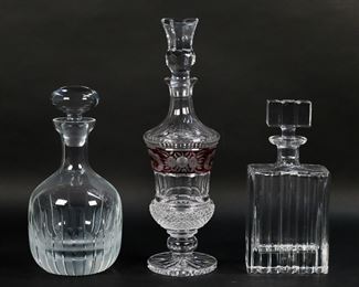 409	3 Crystal Decanters	3 crystal decanters. 2 mid-century modern decanters, larger signed Block, 10 1/8"H and 11"H; Ebeling and Reuss decanter with etched ruby glass panel, unsigned, 15"H. Fleabites to underside of rectangular decanter.
