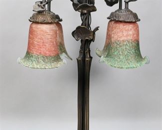 412	Tiffany Style Lily Pad Lamp	Tiffany style lily pad lamp. Patinated metal, four lights, art glass shades. All unsigned. 22 1/4"H. Roughness and fleabites to rims of shades at fittings, one shade rim chipped at fitting.
