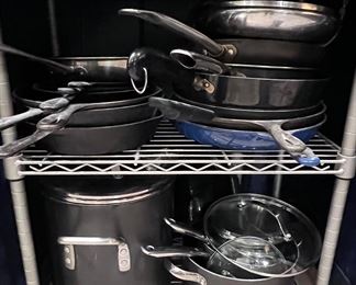 Assorted cookware including several cast iron skillets