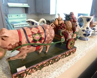 Pig pulling a cart. This item was done by artist Jim Shore, titled "This little piggy". Very collectible.