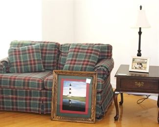 Loveseat shown with end table and home decorative items.